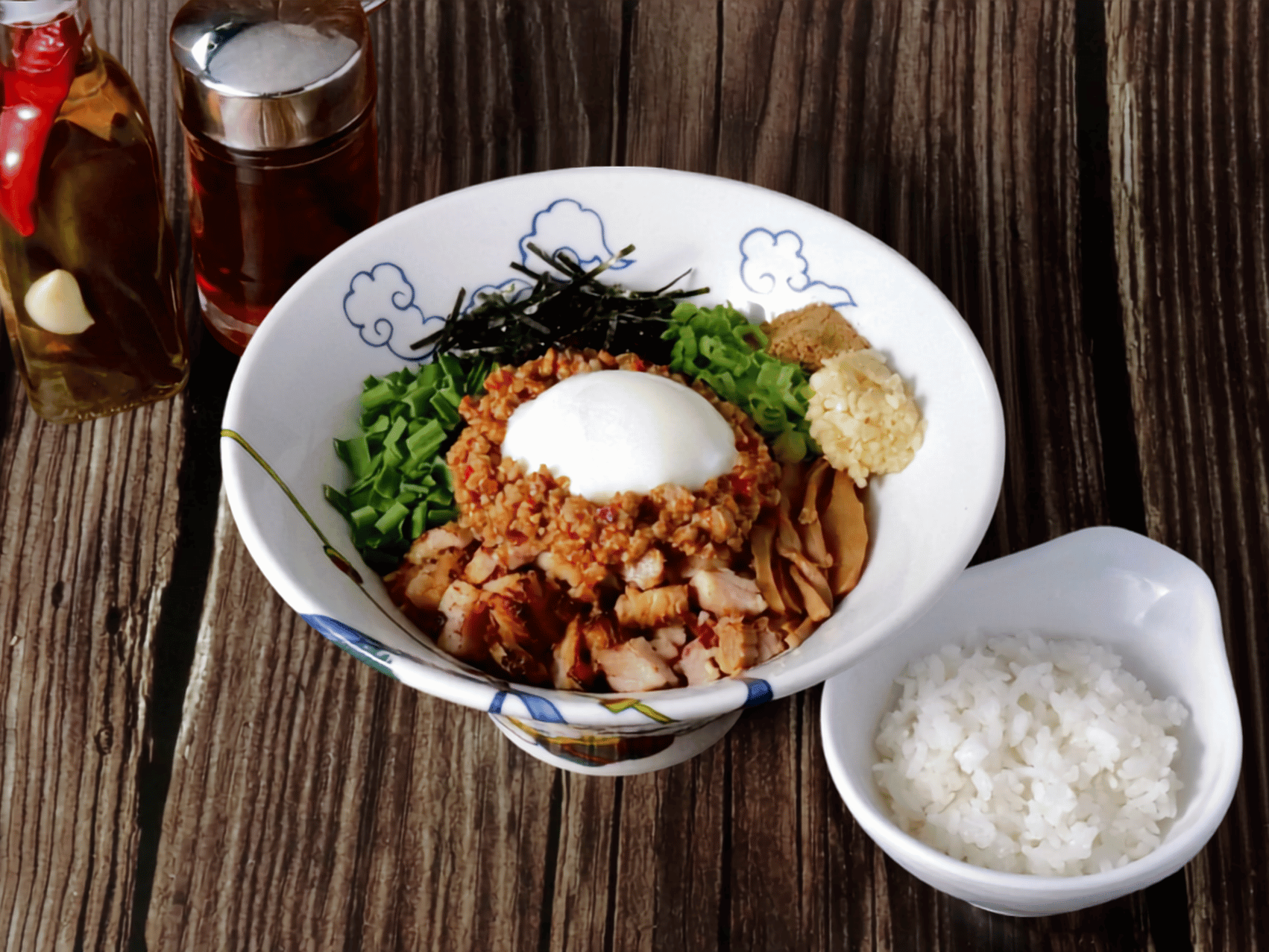 RAMEN RAIJIN Spicy Taiwanese Mazesoba — soupless ramen with spicy Taiwanese minced pork, a poached egg, diced pork chashu, bamboo shoots, chives, green onions, nori seaweed, chopped garlic and dried fish powder, served with rice