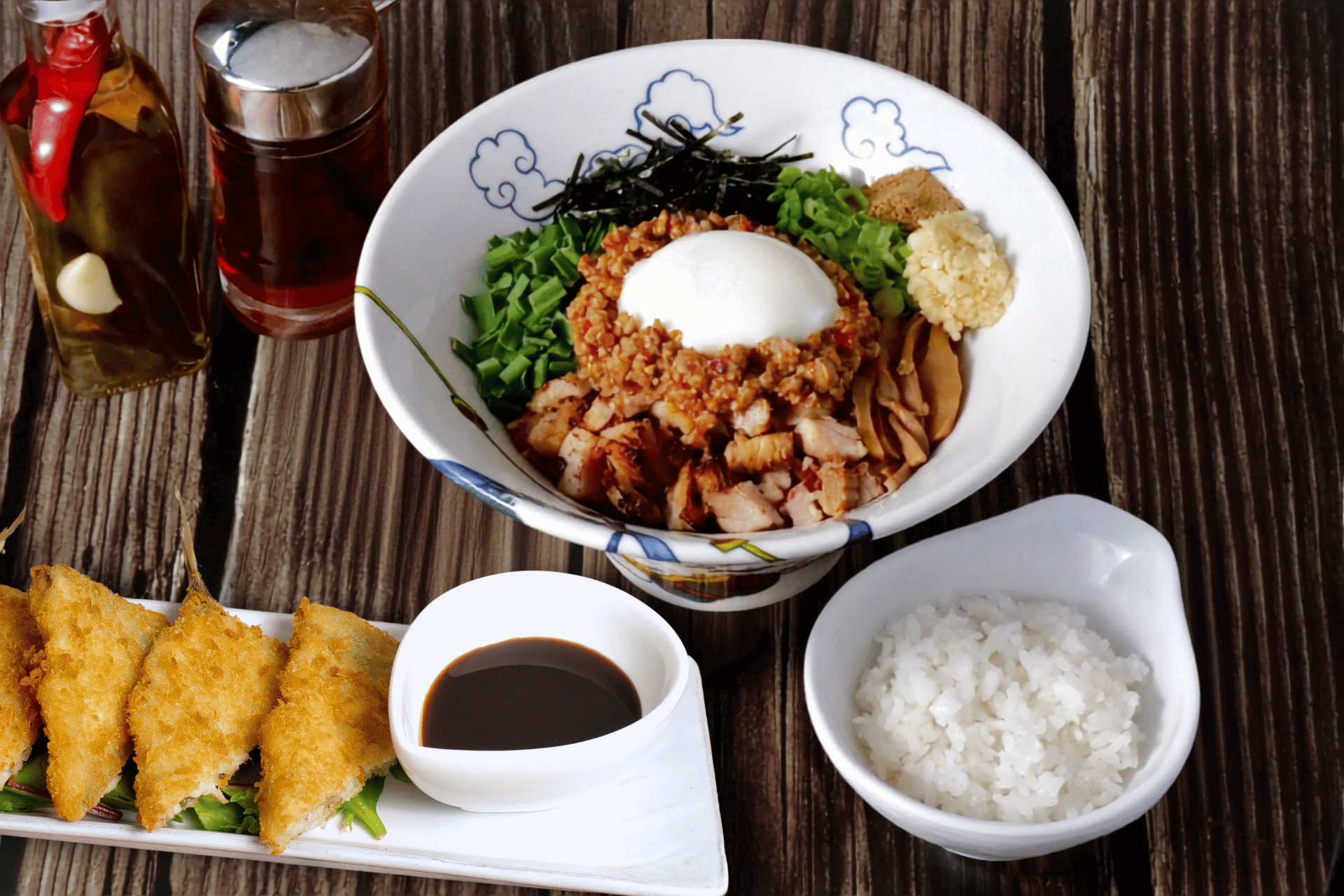 Aji Fry and Spicy Taiwan Mazesoba on the same table at RAMEN RAIJIN Toronto - deep fried horse mackerel with lemon next to a bowl of spicy mazesoba